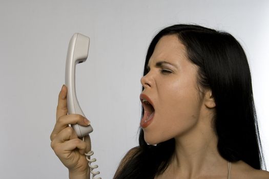 Woman screaming into the telephone in anger