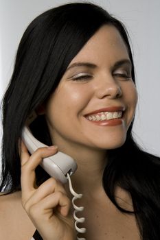woman laughing and smiling while on the phone