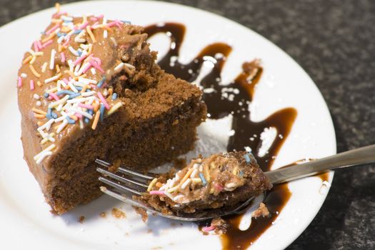 Slice of rich chocolate cake on mottled grey background