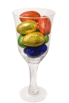 Goblet filled with easter eggs on white background