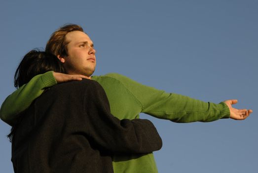 young couple with the sky as background