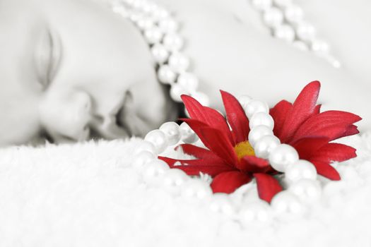 Beautiful baby girl sleeping, pearls draped with flower.  FOCUS ON FLOWER AND PEARLS.