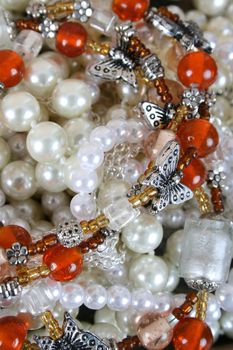Variety of orange beads and pearls with butterfly decorations
