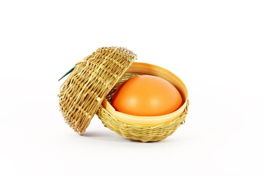 Chicken egg in a little basket isolated on white