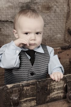 Baby boy playing inside an antique trunk