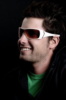 Attractive male wearing sunglasses against black background