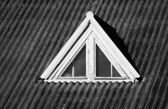 Closed wooden window on the old roof , black and white photo