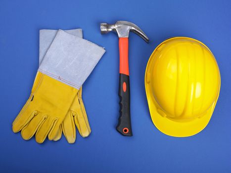 Worker equipment - HardHat Hammer And Leather Gloves on blue