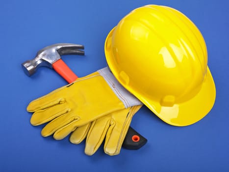 Worker equipment - HardHat Hammer And Leather Gloves on Blue