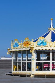 Merry-go-round or roundabout at the beach on sunny day with blue sky background