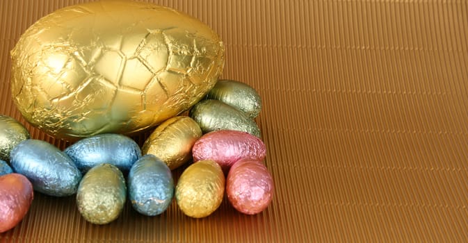 Various colors and shaped easter eggs on a gold background