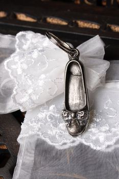 Silver Cast shoe on a keyring with a white organza bag