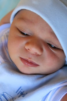 Close up of a Week old baby boy on a blue blanket early in the morning