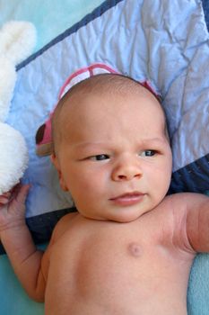 Week old baby boy on a blue blanket early in the morning