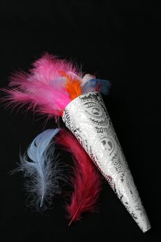 Brightly colored feather confetti in a cone