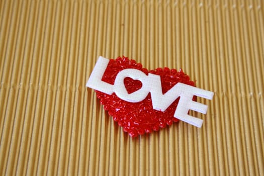 A soft red heart with the word love in white