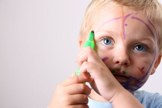 Laughing Toddler playing with colored pens making a mess