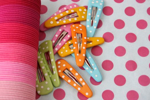 Brightly colored polka dot hair accessories on a polka dot background