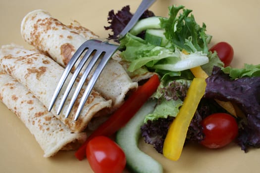 Fresh Salad and pancakes with a fork
