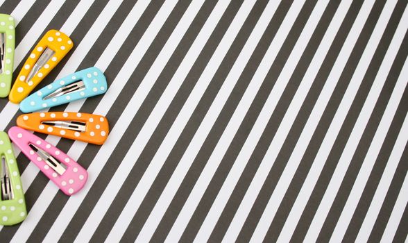 Brightly colored polka dot hair accessories on a striped background