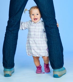 cute baby girl in pink and white stylish outfit with parents in studio