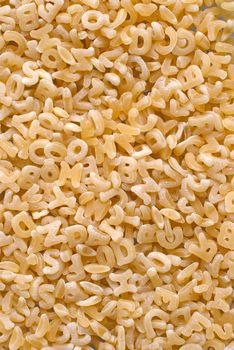 Close-up background of alphabet noodle showing letters.
