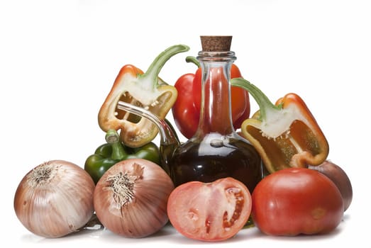 Olive oil and some vegetables like tomatoes, peppers and onions to make gazpacho isolated over a white background.