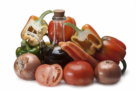 Olive oil and some vegetables like tomatoes, peppers and onions to make gazpacho isolated over a white background.