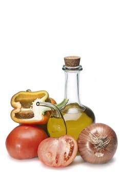 Olive oil and some vegetables like tomatoes, peppers and onions to make gazpacho isolated over a white background.