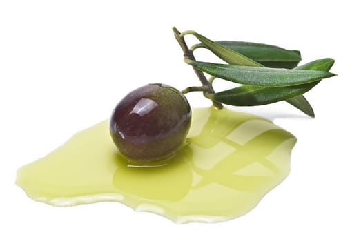 Green olive with leaves on some olive oil and isolated over a white background.