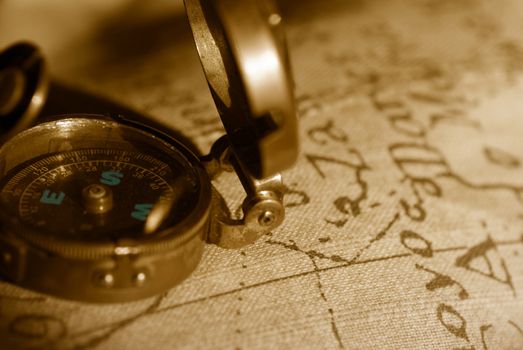 ancient compass and map in sepia tone 