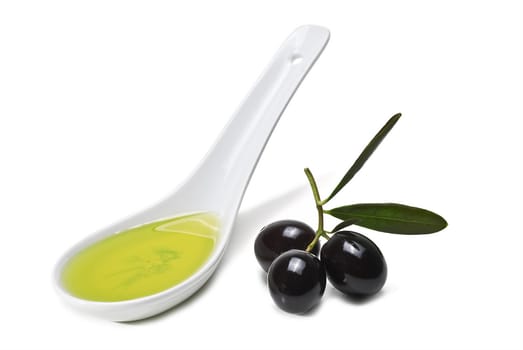 Black olives and a spoonful of olive oil isolated over a white background.