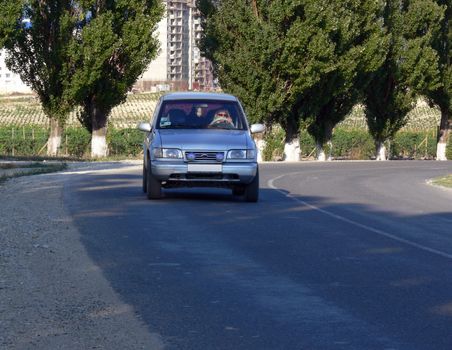 Silver-blue car driving on the empty road