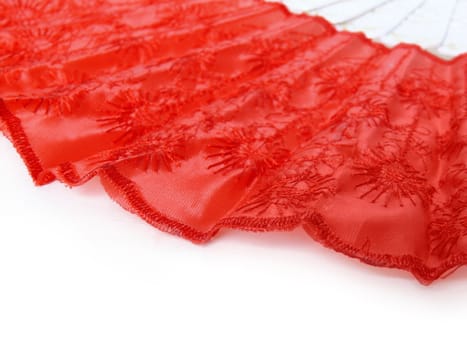 Part of red fan lying on white surface. Abstract red and white background.