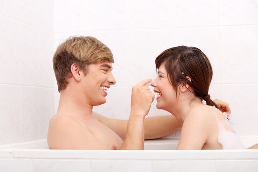 Young happy couple taking bath together.