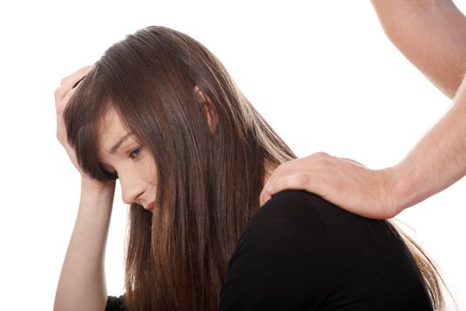 Troubled young girl comforted by her boyfriend. Isolated on white background.