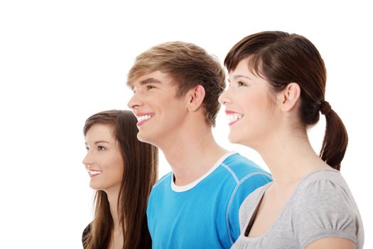 Three young happy friends. Two girls one boy smiling and looking left. Focus on male. Isolated on white background.