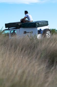 Sitting on the roof of the car in central kalahari desert