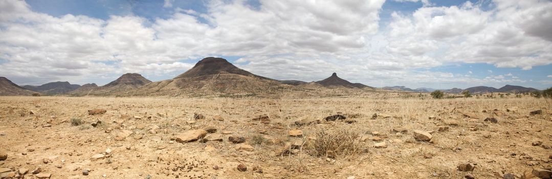 Kaokoland game reserve in Namibia, sand track going toward the Skeleton Coast Desert with a blue sky