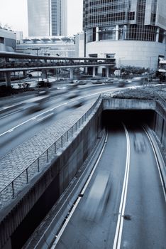 Modern city scenery with cars motion blurred on road in Hong Kong.