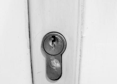 Keyhole on white wooden door close up photo