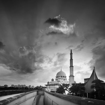 Mosque under dramatic sky in sunset in black and white.