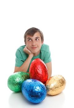 Boy with very large easter eggs is looking sideways.  Thinking pondering wishing.  Space for text.  White background.