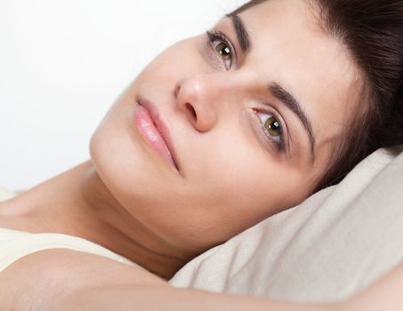 Closeup portrait of pretty young woman in bed