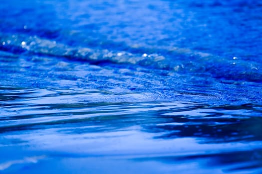 Small wave on sand beach close up photo