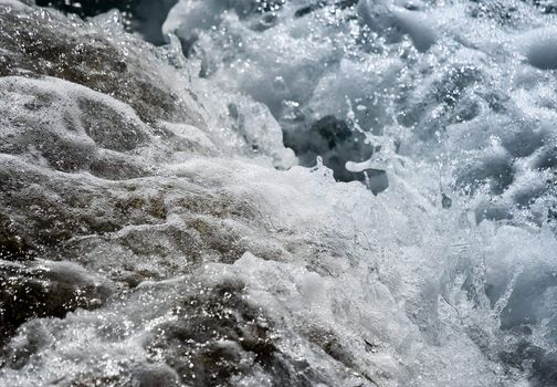 Wild water splash - small wave crashing on the shore close up  