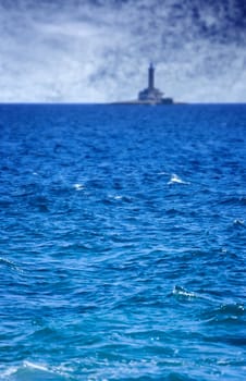 Sea before the storm and old lighthouse in the background