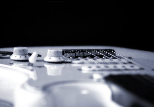 White electric guitar on black background