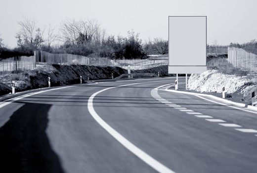 Photo of the highway with a big blank sign on the side of the road