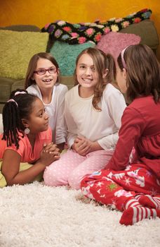 Little girl wrings hands with friends at a sleepover